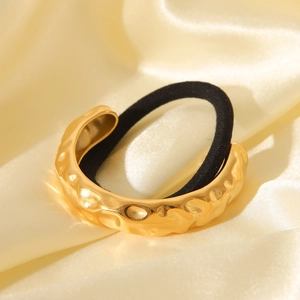 Hammered 18K gold stainless steel hair cuff with black elastic on golden silk background