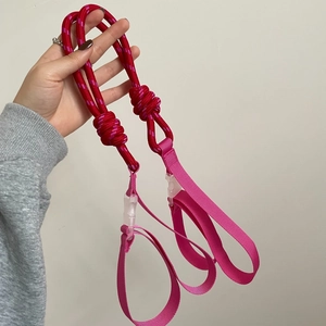 Vista a mano di un cinturino in nylon intrecciato viola e rosso con fibbia regolabile