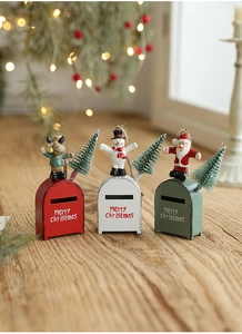 Detailed view of three festive metal Christmas mailboxes with elk and Santa figurines