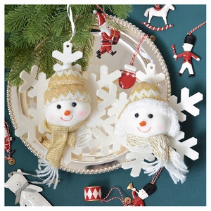Close-up of plush snowman ornaments with knit hats and scarves on festive background