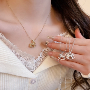 Detail of rocking horse necklaces in gold and silver finishes worn by a model