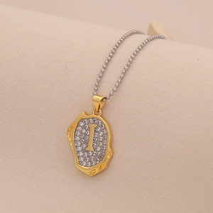 Macro shot of gold letter I pendant with rhinestones on a silver bead chain