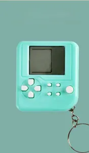 Close-up of mint green mini tetris game console keychain with black and white LCD screen