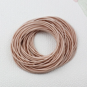 Detail view of 1.7mm rose gold spring steel wire bracelet with screw clasp on white leather
