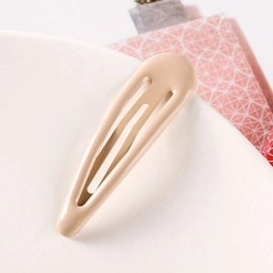 Close-up of a 5cm teardrop-shaped candy color metal BB hair clip on a ceramic tray
