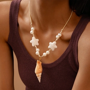 Bohemian style necklace with spiral shell and starfish pendant worn by a model