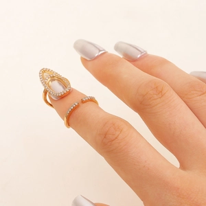 Detail of gold zircon nail ring with teardrop cutout and shimmering stone settings