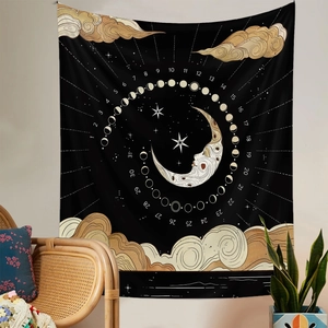 Detail of bohemian wall tapestry featuring golden moon phases and stars on black fabric