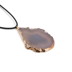 Macro detail of natural agate slice pendant with gold plated edges on black leather cord