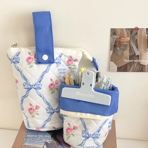 Detail van een bloemrijke etui met strik en pennen in een draagbare organisator