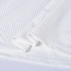 Detailed close-up of white ribbed knit fabric featuring high-quality double-needle stitching