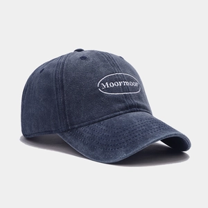 Detailed close-up of dark blue washed cotton baseball cap with Moormoor embroidery