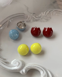 Détail macro de boucles d'oreilles boules géométriques sur un plateau en céramique