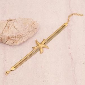 Detail of gold double-layer snake chain bracelet with starfish charm and lobster clasp