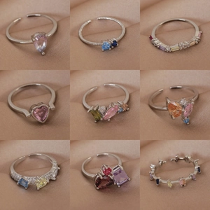 Colorful micro-pave zircon rings in various gemstone cuts on a beige silk surface