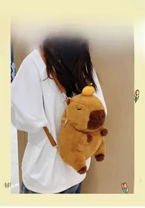 Detail view of plush capybara backpack featuring soft brown fur and orange fruit accessory