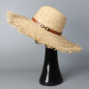 Wide brim raffia straw hat with frayed edges and brown leather band with gold buckle