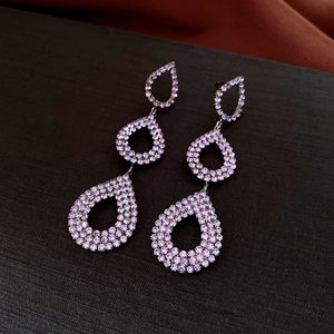 Detail view of purple crystal teardrop earrings with triple cascading tassel design