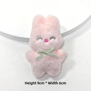 Gros plan d'un pendentif lapin en peluche rose de 9cm avec ruban vert et broderies
