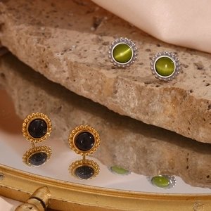 Detail of round cat eye stone earrings with beaded vintage frames in gold and silver