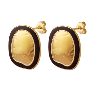 Vintage retro gold hammered oval earrings with black enamel border on white background