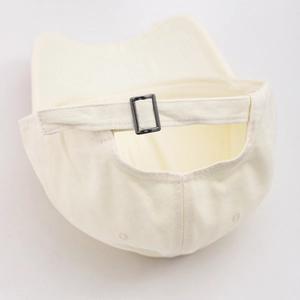 Detail view of the beige denim baseball cap featuring a metal buckle and adjustable strap