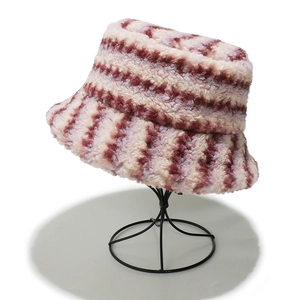 Detail of plush lamb wool bucket hat featuring gradient wine red and pink stripes