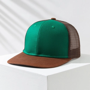 Detail of green and brown mesh trucker hat with flat brim on a minimalist white stand