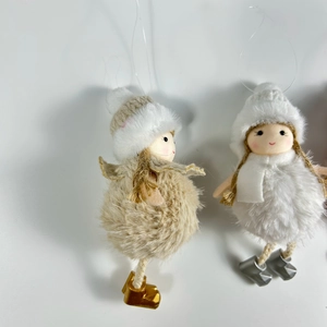 Close-up of plush Christmas angel ornaments in beige and white with faux fur details