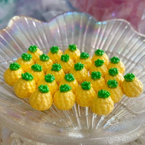 Vista macro di mini ciondoli a forma di ananas in resina in una ciotola di vetro