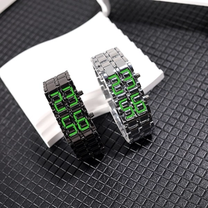 Close-up of black and silver LED lava watches with green display on mesh surface