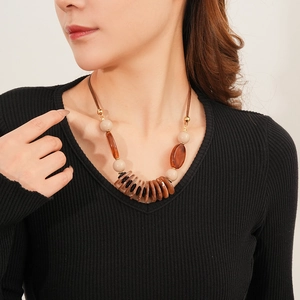 Detailed close-up of a double-layered brown leather necklace with vintage oval beads