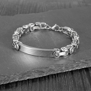 Detailed close-up of a silver Byzantine chain bracelet with blank metal plate on stone