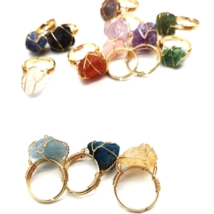 Detail of handmade wire-wrapped rings featuring colorful natural raw agate crystals