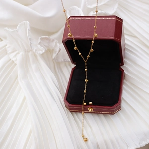 Elegant gold Y-shaped beaded tassel necklace in red leather jewelry gift box