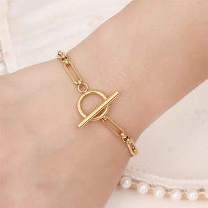Golden stainless steel chain bracelet with T-bar OT clasp shown on a wrist with pearls