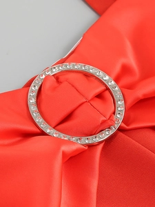Detailaufnahme von rotem Satinstoff mit einer silbernen, strassbesetzten O-Ring-Schnalle