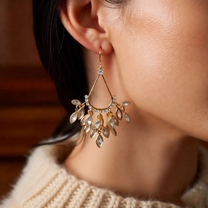 Macro detail of 18k gold plated teardrop tassel earrings with sparkling zircon crystals