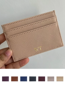 Macro shot of Saffiano leather card holder in beige with gold-tone embossed WT logo details