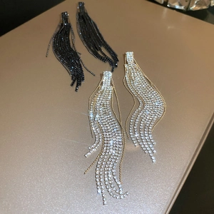 Macro detail of geometric silver and black rhinestone fringe earrings on gift box