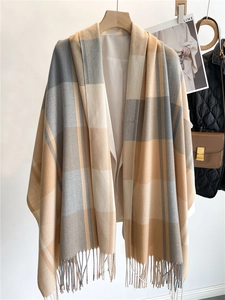Dettaglio di sciarpa a quadri beige, grigia e caffè con finiture a frange