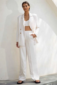 Detail of white double-breasted suit blazer with matching crop top and wide-leg trousers