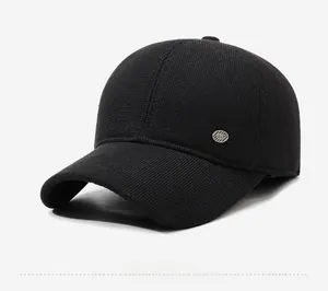 Detail view of black winter baseball cap showing thick knit texture and side metal emblem