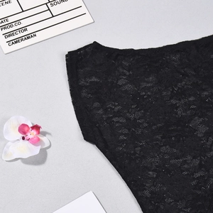 Gros plan sur un haut en dentelle noire avec des motifs floraux évidés et texture fine