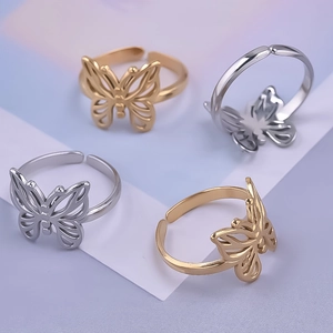 Detail of four butterfly open rings in gold and silver with delicate hollowed-out metal design