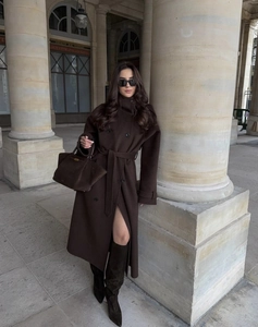 Dettaglio del cappotto di lana marrone scuro con design doppiopetto e cintura in vita