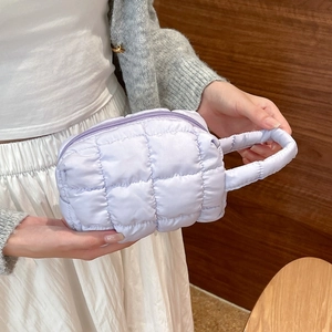 Close-up of a lavender quilted cylindrical makeup bag with a zipper and top handle