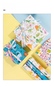 Detail of dinosaur cartoon gift wrapping paper with Happy Birthday ribbons and vibrant boxes