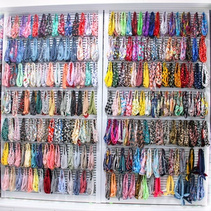 Close-up of vibrant velvet tie-dye scrunchies and headbands displayed on organized racks