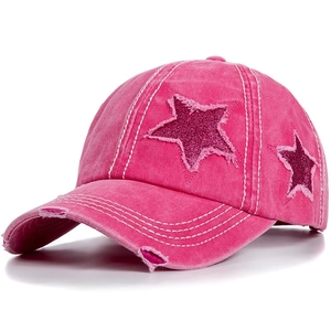 Dettaglio del berretto in cotone rosa con stella di paillettes e tesa sfrangiata